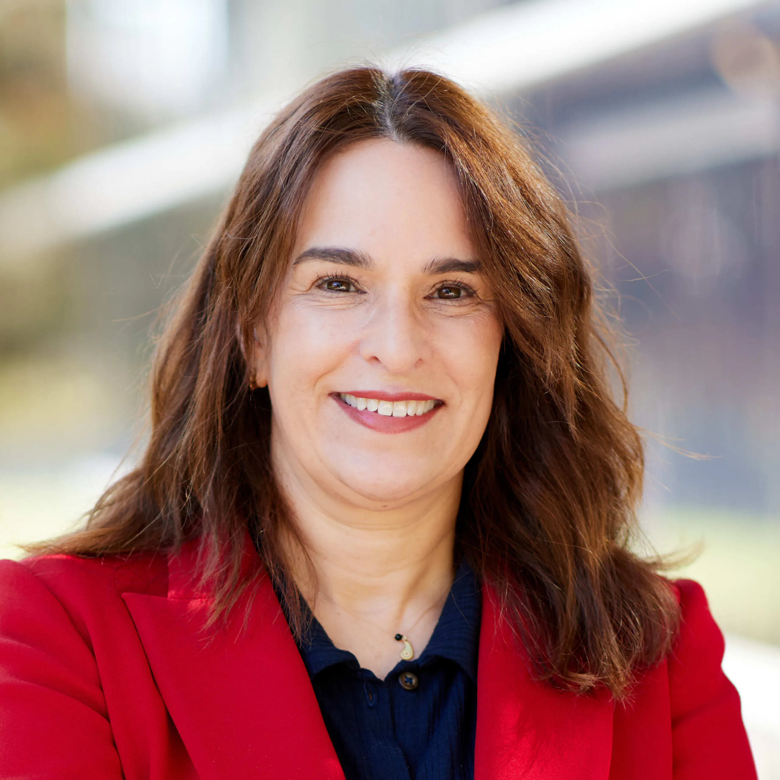 woman wearing red jacket smiling into camera
